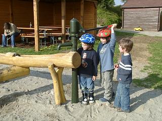 Drei Kinder an einer Wasserpumpe