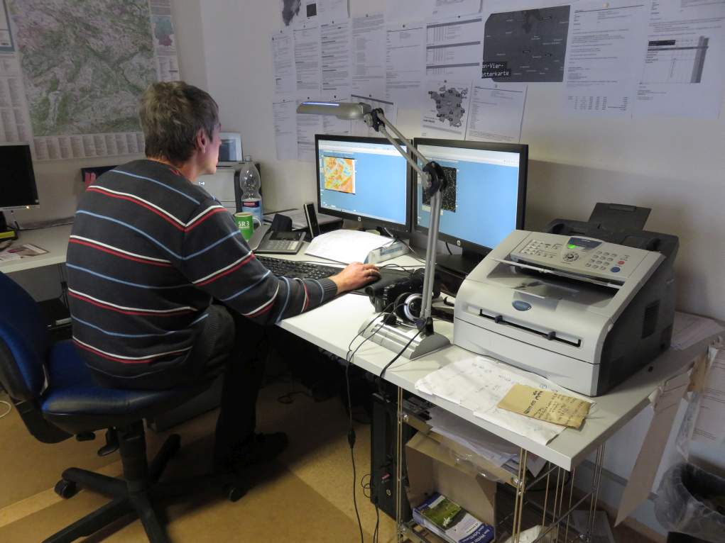 Der Meteorologe mit Kopfhörer vor einem Bildschirm